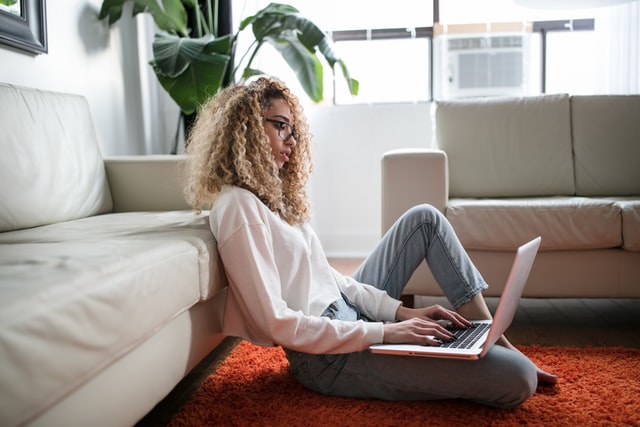 ソファにもたれてPCを見る女性